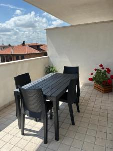 una mesa de madera y sillas en un patio en HOGAR MAMI, en Rímini