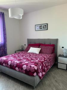 - une chambre avec un lit et une couette violette dans l'établissement HOGAR MAMI, à Rimini