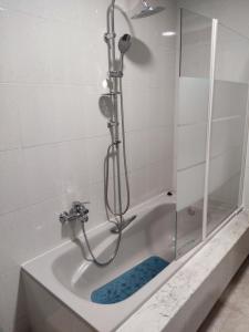 a bath tub with a shower with a glass door at CU Apartamentos Pampin Ponte Do Porto in Ponte Do Porto +18 photos