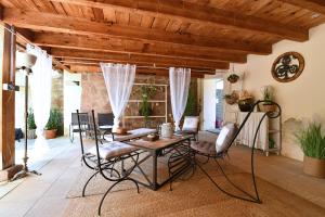 un soggiorno con soffitto in legno, tavolo e sedie. di La Longère des Capucines a Bergholtz