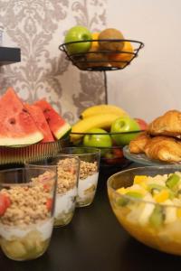 einen Tisch mit Schalen verschiedener Arten von Lebensmitteln in der Unterkunft Garni Hotel VIRGO in Bratislava