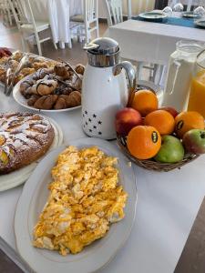 una mesa cubierta con platos de desayuno y fruta en Sanremo Hotel Restorant, en Durrës