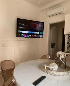 tavolo da pranzo con TV a parete di B&B a Pompei Gaudium da 1 a 5 posti letto a Scafati