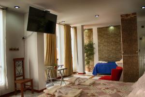 1 dormitorio con 1 cama y TV en la pared en Hosting Home - Casa Bella, en Cajamarca