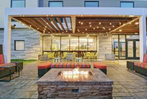 een patio met een vuurplaats en tafels en stoelen bij Home2 Suites By Hilton Clarksville Louisville North in Clarksville
