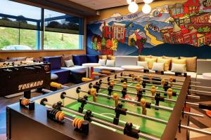 une salle de jeux avec des billards et une grande fresque murale. dans l'établissement Tru By Hilton Staunton, à Staunton