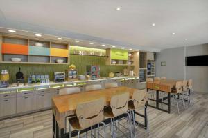 a kitchen with a large wooden table and chairs at Home2 Suites By Hilton Clarksville Louisville North in Clarksville