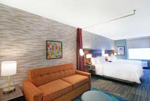 a hotel room with a bed and a couch at Home2 Suites By Hilton Clarksville Louisville North in Clarksville +39 photos