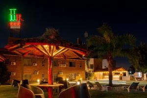 une table avec un parasol devant un bâtiment dans l'établissement Riviera Hotel & Spa, à Villa Carlos Paz