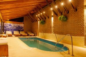 a swimming pool in a room with a brick wall at Riviera Hotel & Spa in Villa Carlos Paz