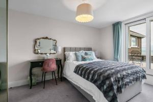um quarto com uma cama, uma secretária e um espelho em Skippingstone Beach Loft With Amazing Sea Views em Bangor