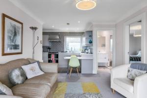 uma sala de estar com um sofá e uma cozinha em Skippingstone Beach Loft With Amazing Sea Views em Bangor