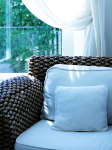un divano con cuscino di fronte a una finestra di Hotel La Pigna a Marina di Pietrasanta