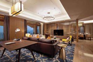 a living room with a couch and a table at Doubletree By Hilton Huidong Resort in Huidong