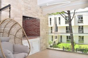 eine Veranda mit einem Schaukelstuhl und einem großen Fenster in der Unterkunft Olive Tree Apartment - 290 in Mullini i Danit