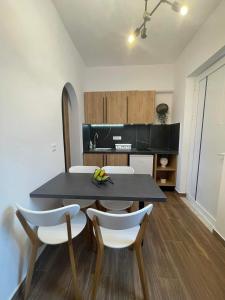Gennadi Beach Apartments في غينادي: مطبخ مع طاولة سوداء وكراسي بيضاء