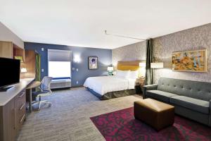 um quarto de hotel com uma cama e um sofá em Home2 Suites By Hilton Warner Robins em Warner Robins