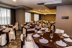 Hampton Inn & Suites By Hilton Puebla في بوبلا: قاعة احتفالات كبيرة مع طاولات وكراسي مع كؤوس للنبيذ