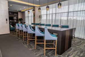 une salle de conférence avec une grande table et des chaises bleues dans l'établissement Hampton Inn & Suites By Hilton Puebla, à Puebla
