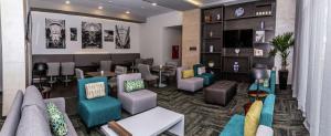a lobby with a waiting room with chairs and tables at Hampton Inn & Suites By Hilton Puebla in Puebla
