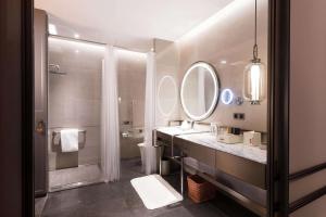 a bathroom with a sink and a toilet and a mirror at Canopy by Hilton Chengdu City Centre in Chengdu