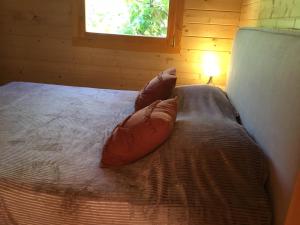 a bed with two pillows on it in a room at CHALET MARYVONNE in Les Vans +13 photos
