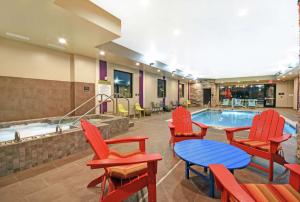 una piscina con sillas, mesa y mesa en Home2 Suites By Hilton Beloit en Beloit