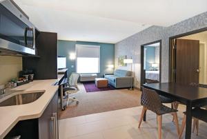 伯洛伊特Home2 Suites By Hilton Beloit的一间带厨房和客厅的房间