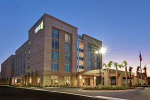 un hôtel avec des palmiers devant dans l'établissement Home2 Suites Charleston West Ashley, à Charleston