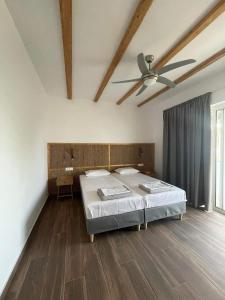 a bedroom with a bed and a ceiling fan at Gennadi Beach Apartments in Gennadi