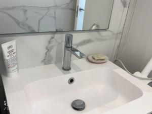 La salle de bains est pourvue d'un lavabo blanc et d'un miroir. dans l'établissement Apartment near by downtown beach, à Barcelone