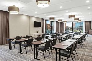 a dining room with tables and chairs and a flat screen tv at Homewood Suites by Hilton Providence Downtown in Providence