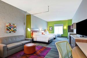 um quarto de hotel com uma cama e um sofá em Home2 Suites Charleston West Ashley em Charleston