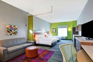チャールストンにあるHome2 Suites Charleston West Ashleyのベッドとソファ付きのホテルルーム