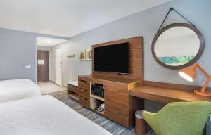 a hotel room with a television and a mirror at Hampton Inn Simpsonville in Simpsonville