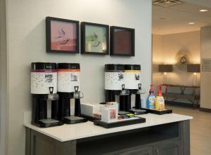 a counter with four coffee machines on it at Hampton Inn & Suites Snellville Atlanta Ne in Snellville