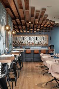 un restaurante con mesas y sillas y un bar en The Sound Hotel Seattle Belltown, Tapestry Collection en Seattle