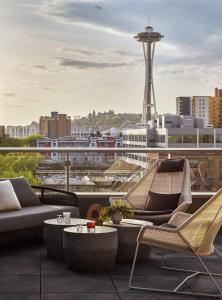 a balcony with chairs and tables and a view of a city at The Sound Hotel Seattle Belltown, Tapestry Collection in Seattle