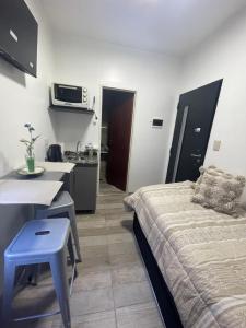 a room with a bed and a table and a kitchen at Espectacular Departamento en Vicente Lopez ,Avenida San Martín 2248 in Vicente López