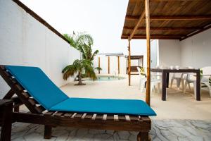 une chaise longue bleue sur une terrasse avec une table dans l'établissement Villa Tokio con jacuzzi y piscina privada, à Chiclana de la Frontera