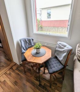 a small table and two chairs in a room with a window at Central Apartments in Vestmannaeyjar