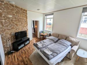 ein Wohnzimmer mit einem Sofa und einem TV in der Unterkunft Central Apartments in Vestmannaeyjar