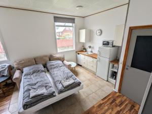 a living room with a couch and a kitchen at Central Apartments in Vestmannaeyjar