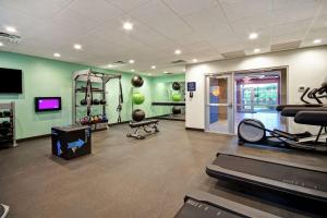 einen Fitnessraum mit Trainingsgeräten in einem Raum mit grünen Wänden in der Unterkunft Tru By Hilton Wytheville Va in Wytheville