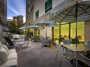 eine Terrasse mit Tischen, Stühlen und Sonnenschirmen in der Unterkunft Hampton Inn & Suites Atlanta Decatur/Emory in Decatur
