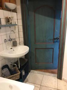 a bathroom with a sink and a blue door at Idylle unter Reet, gemütliche Ferienwohnug in Haseldorf