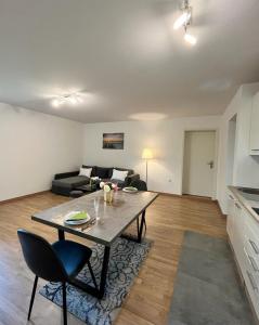 uma sala de estar com uma mesa e um sofá em Confortable appart. en résidence (rez-de-chaussé) em Dudelange