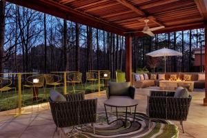 um pátio com cadeiras, uma mesa e uma fogueira em Hampton Inn And Suites By Hilton Johns Creek em Johns Creek