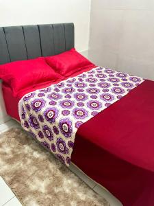 a bed with a red comforter and red pillows at Localizada no centro de Juazeiro in Juazeiro