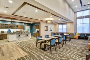 a cafeteria with tables and chairs and a kitchen at Homewood Suites By Hilton Hadley Amherst in Hadley